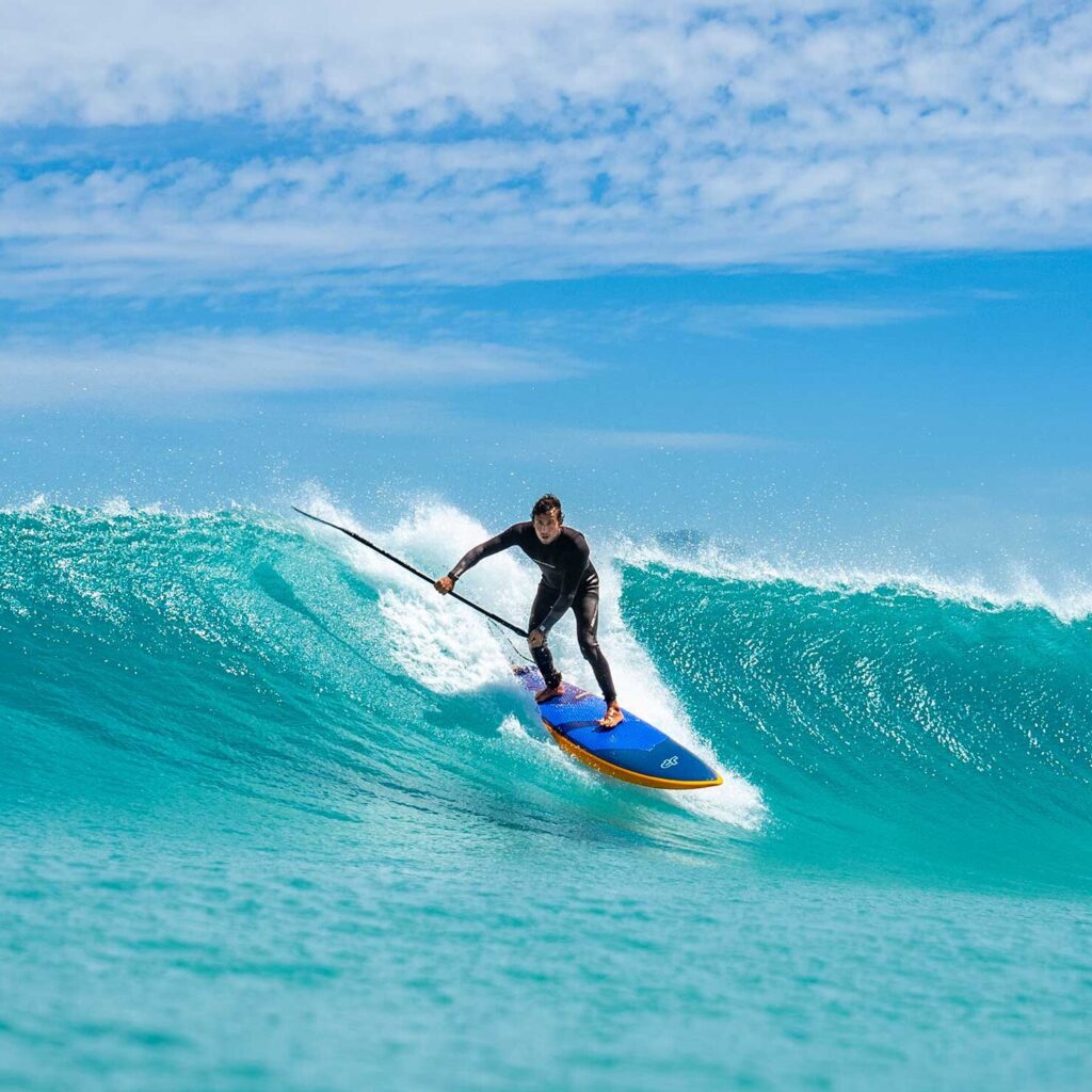 A man stand up paddle boarding in Fiji, SUP in Fiji.