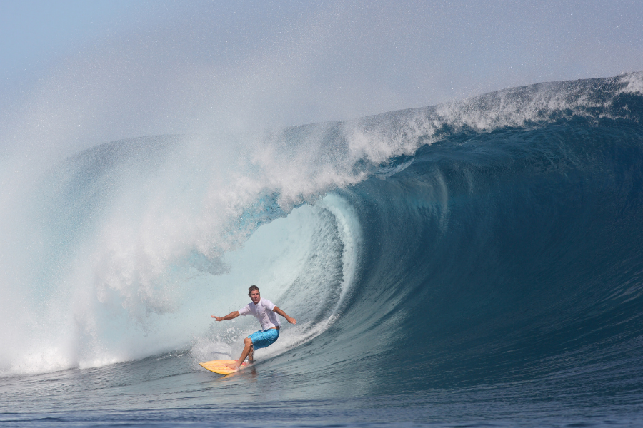 A man rides a huge wave at Cloudbreak in Fiji.  